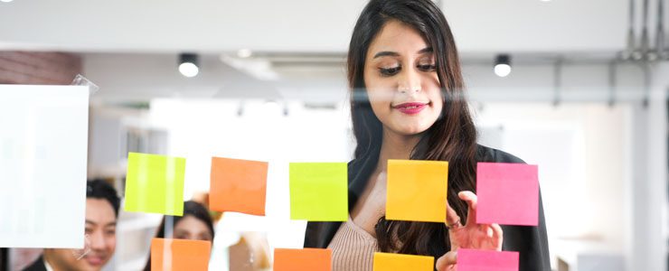 Office worker arranging coloured post-it notes