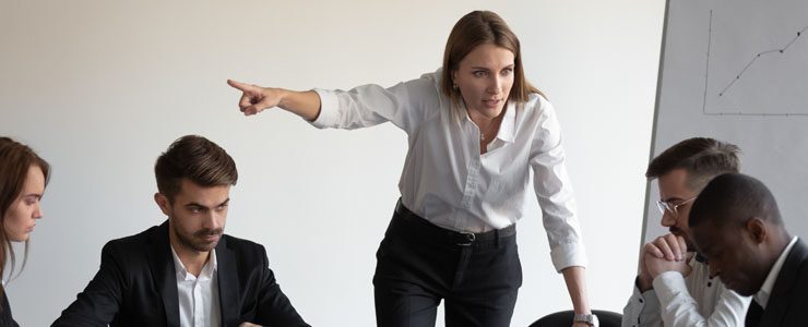 Female boss giving staff a dressing down in a meeting